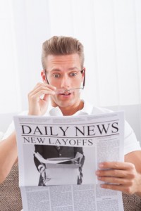 Reading Newspaper With The Headline New Layoffs
